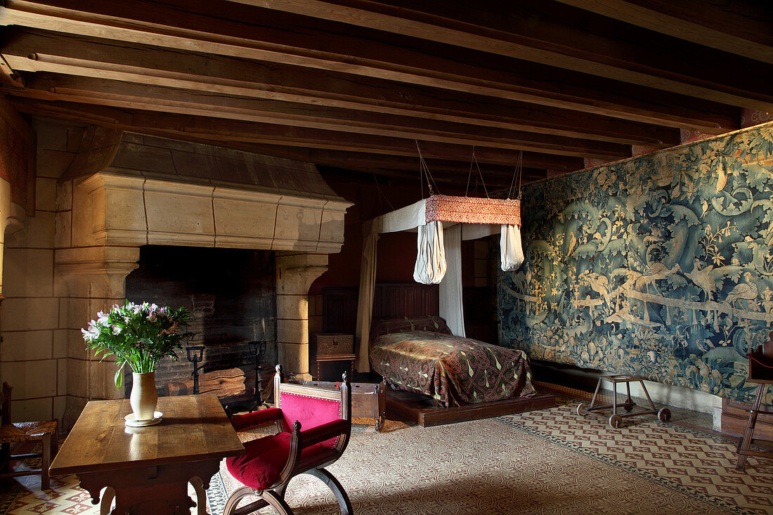 France, Centre France, Touraine, Chateau feodal de Langeais. Inside of the Royal bedroom with tapestry and imposing chimney.