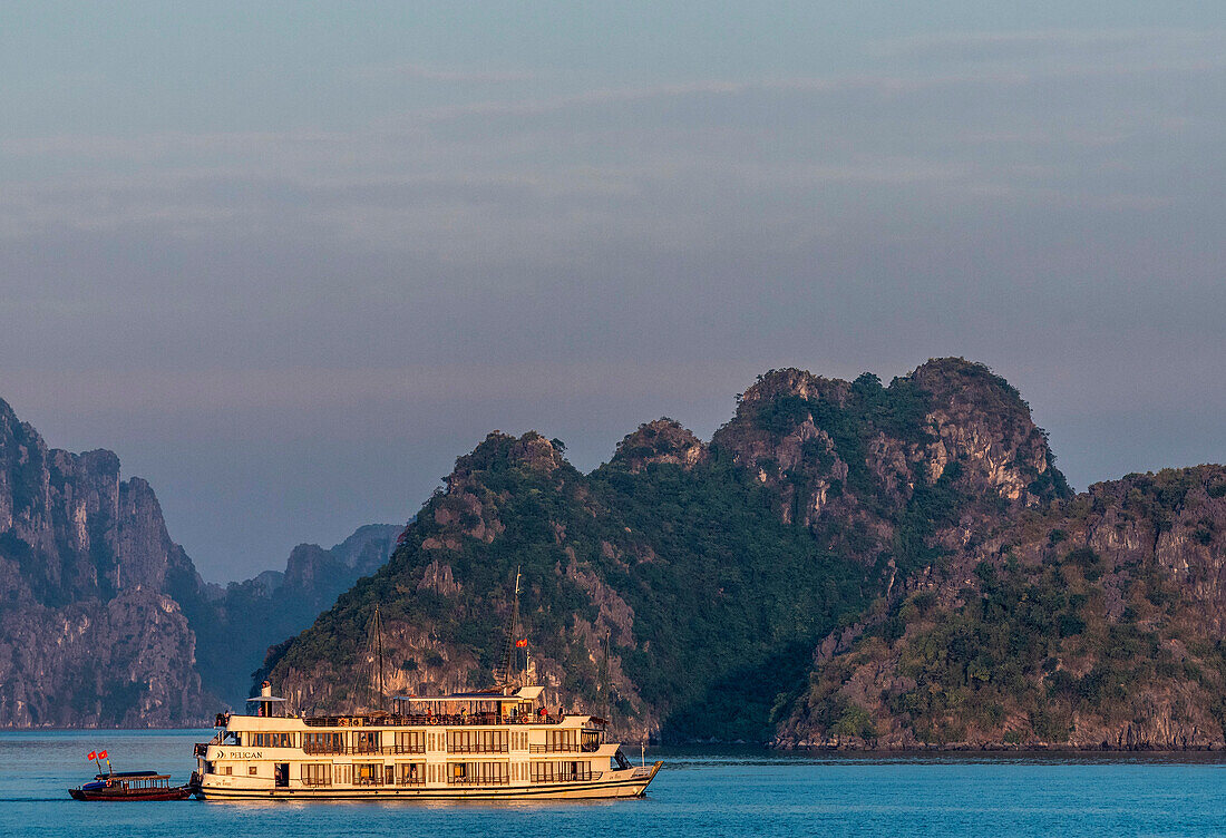 Vietnam, Ha Long Bay, cruise boat at sunset (UNESCO World Heritage)