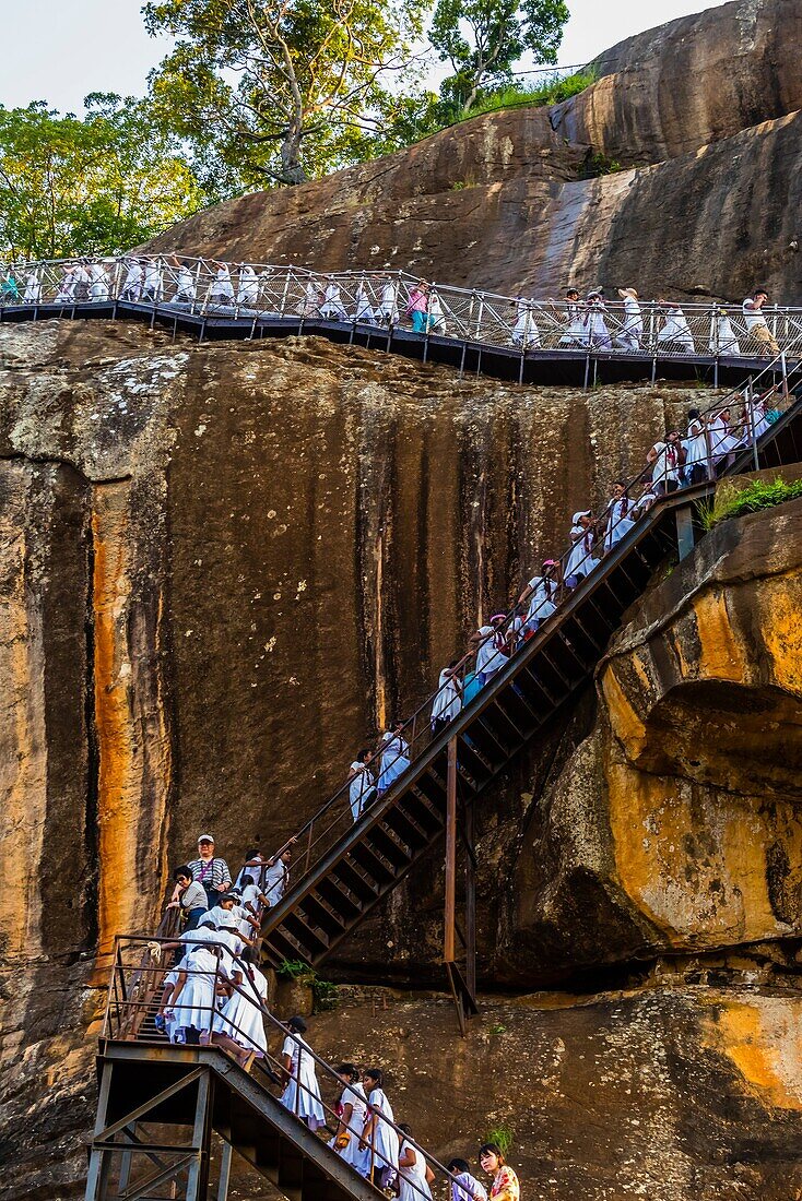 School girls climbing a staircase to the top of Sigiriya Rock (an ancient rock fortress), Central Province, Sri Lanka