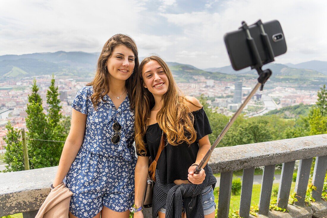 Two girls taking a photo in Bilbao, Biscay, Spain, Europe