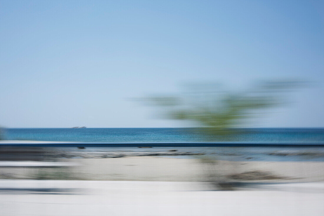 Blurred motion view of beach against clear sky
