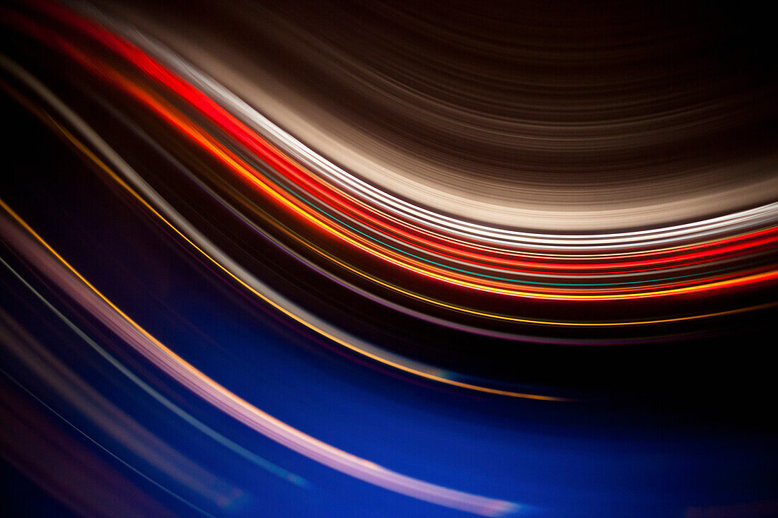 Full frame abstract image of colorful light trails against black background