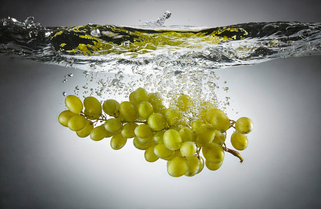 Close-up of green grapes in splashing water