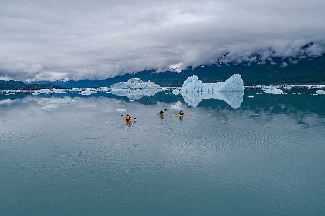 People canoeing in glacier lagoon against cloudy sky, Knik Glacier, Palmer, Alaska, USA