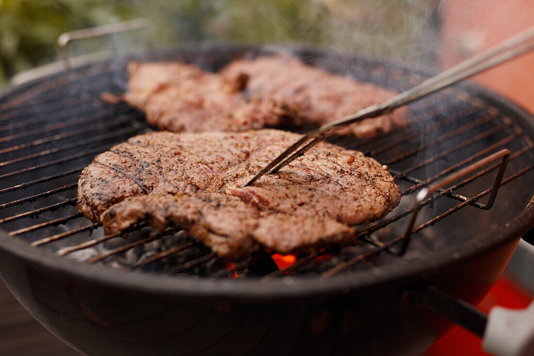 Close-up of steak being grilled on barbecue at patio