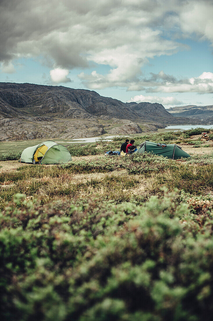 Hiker in front of two tents in greenland, greenland, arctic.