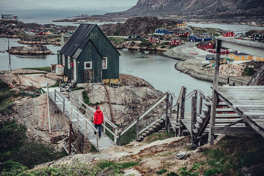 Mann geht auf Steg durch Sisimiut, Grönland, Arktis.