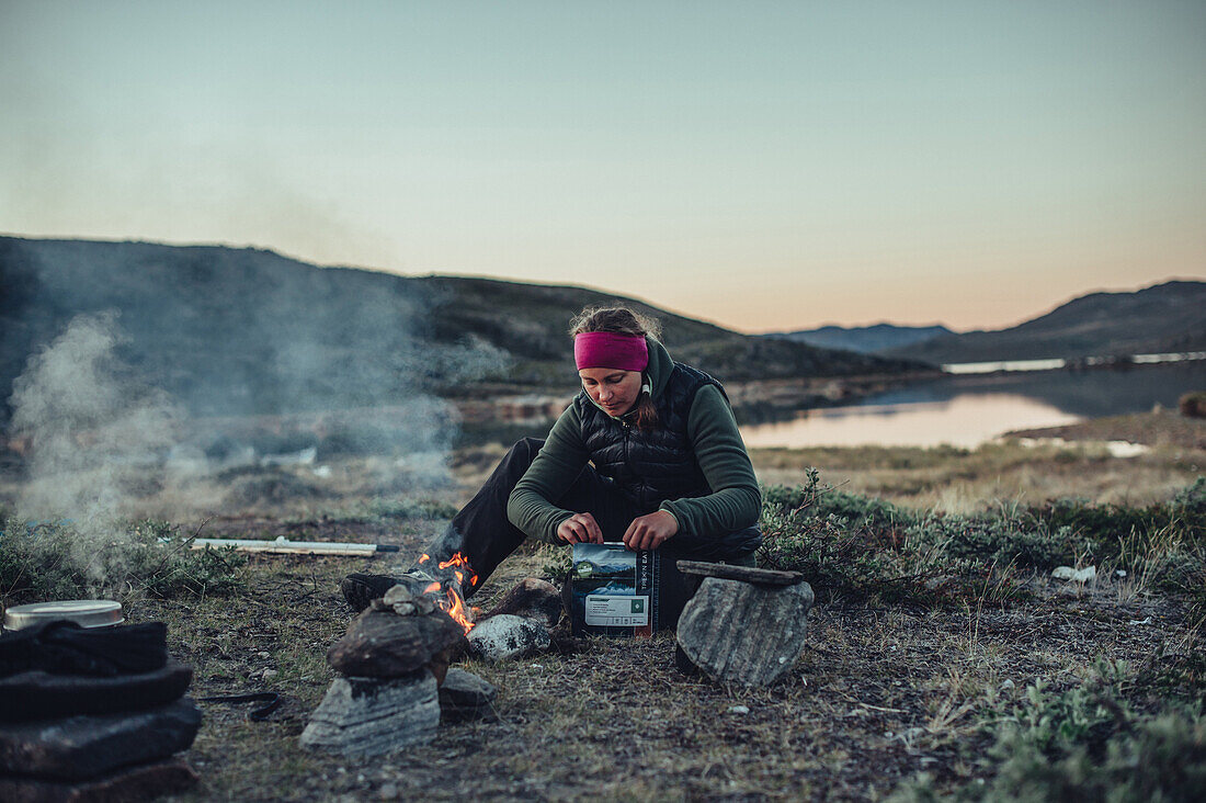 woman cooking an instant meal, greenland, arctic.