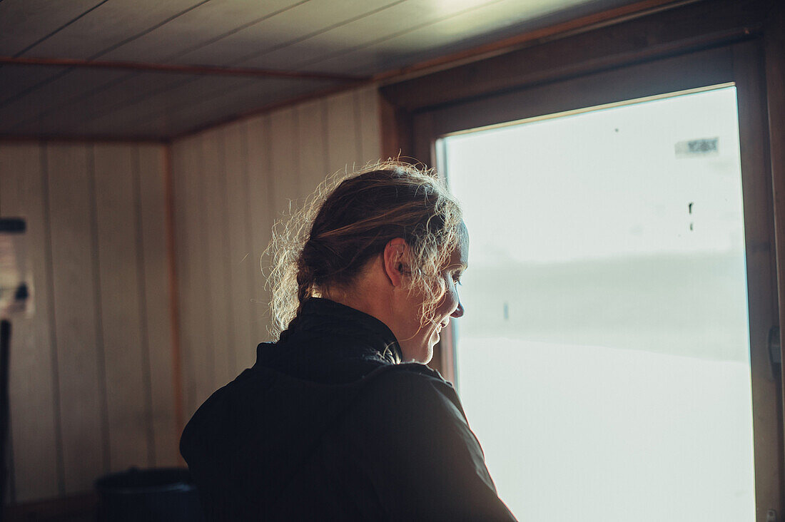Frau kocht in einer Hütte, Grönland, Arktis.