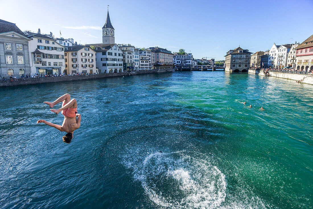 Junger Mann springt von Muentser Breucke in Fluss Limmat, Zuerich, Schweiz
