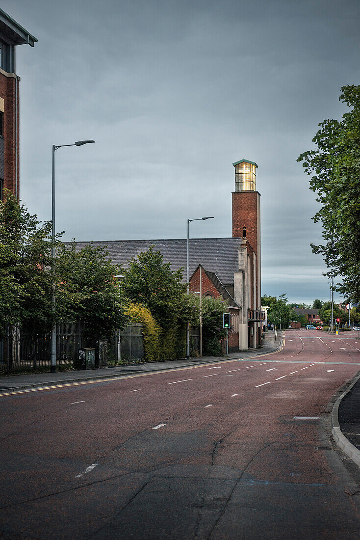 leuchtender Kirchturm an leerer mehrspuriger Straße, Belfast, Nordirland, Vereinigtes Königreich Großbritannien, UK, Europa