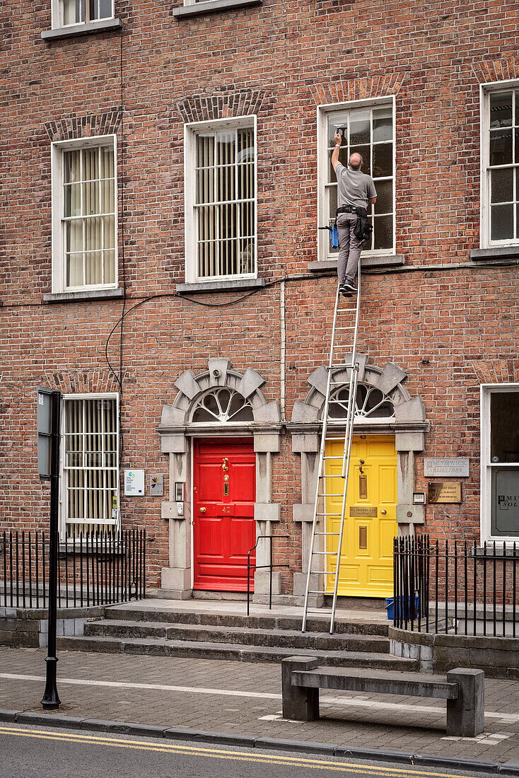 bunte Haustüren und Fensterputzer in Kilkenny, Grafschaft Kilkenny, Irland, Europa
