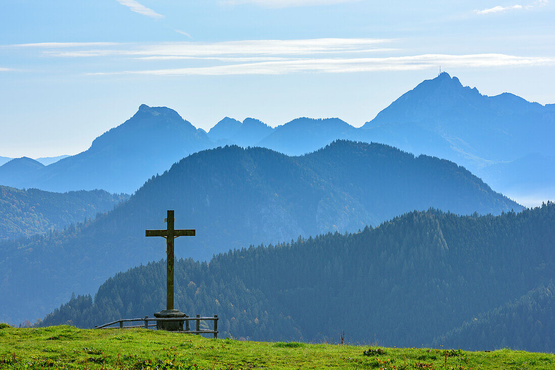 Kreuz steht auf Bergwiese, Breitenstein und Wendelstein im Hintergrund, Kreuzbergalm, Gindelalmschneid, Bayerische Alpen, Oberbayern, Bayern, Deutschland
