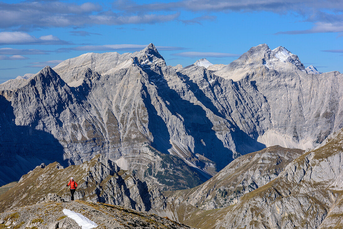 Woman hiking ascending towards Sonnjoch, Kaltwasserkarspitze, Birkkarspitze and Oedkarspitze in background, Sonnjoch, Karwendel, Natural Park Karwendel, Tyrol, Austria