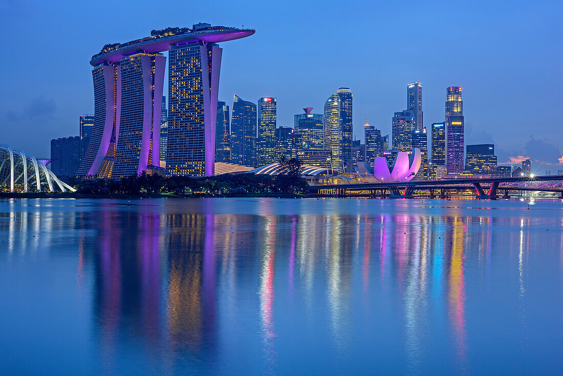 Illuminated skyline of Singapore with Marina Bay Sands and ArtScience Museum, reflecting in Marina Bay, Singapore