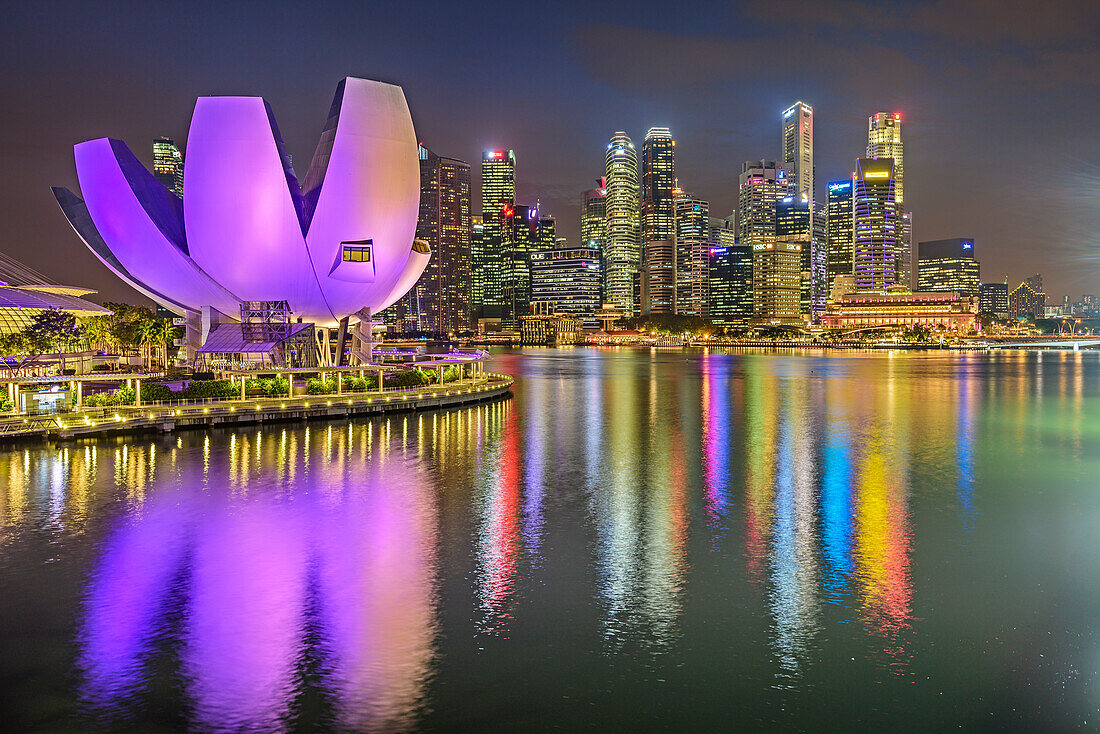 Illuminated skyline of Singapore with ArtScience Museum and Financial District reflecting in Marina Bay, Singapore