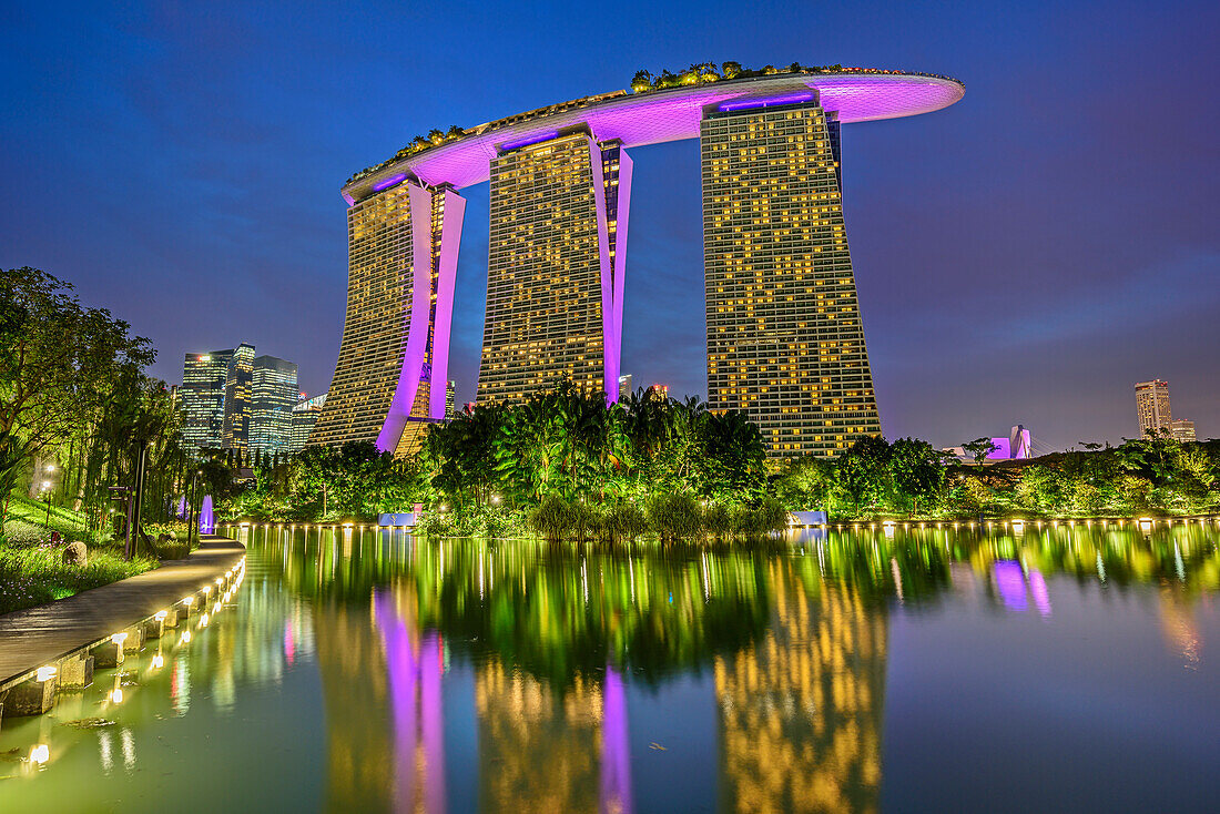 Illuminated Marina Bay Sands reflecting in lake at Garden of the Bay, Marina Bay, Singapore