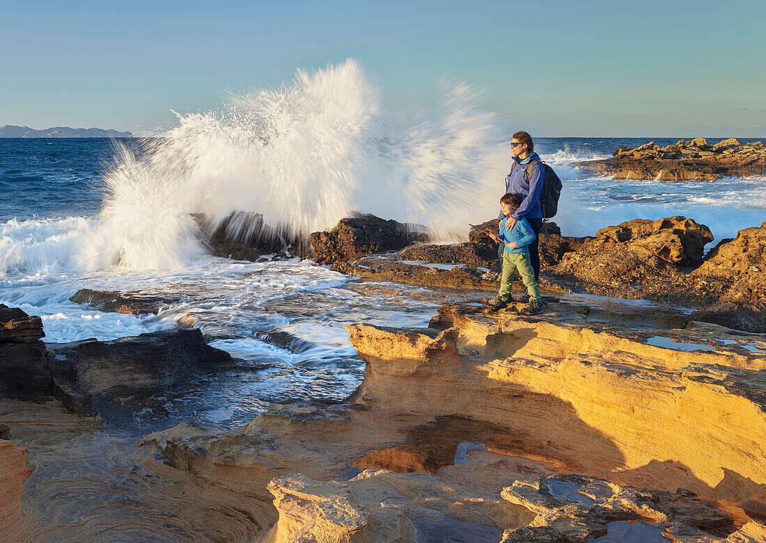 young woman with child, sandstone formations on the coast at Betlem, Badia d'Alcudia, Mallorca, Balearic Islands, Spain