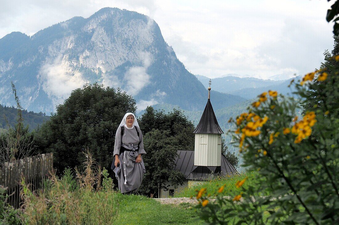 Nun at the Antonius cupel in the Kaiser valley, Kaiser mountains over Kufstein, Tyrol, Austria