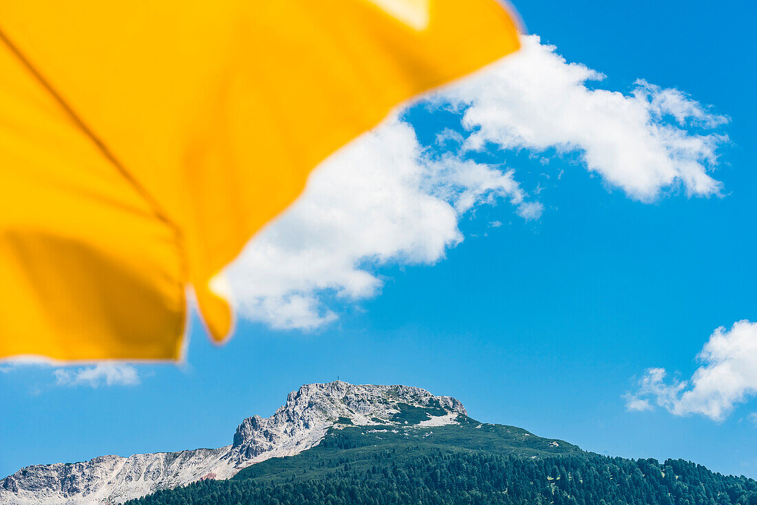 Blick vorbei an einem gelben Sonnenschirm auf das Weißhorn mit dem angrenzenden Bletterbach UNESCO World Heritage, Aldein, Südtirol, Alto Adige, Italien