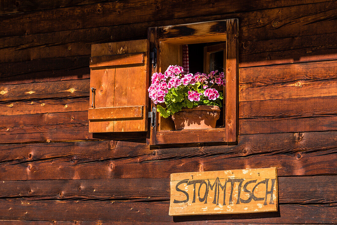 Signpost to a regulars' table at a mountain hut with geraniums in the window, Compatsch, South Tyrol, Alto Adige, Italy