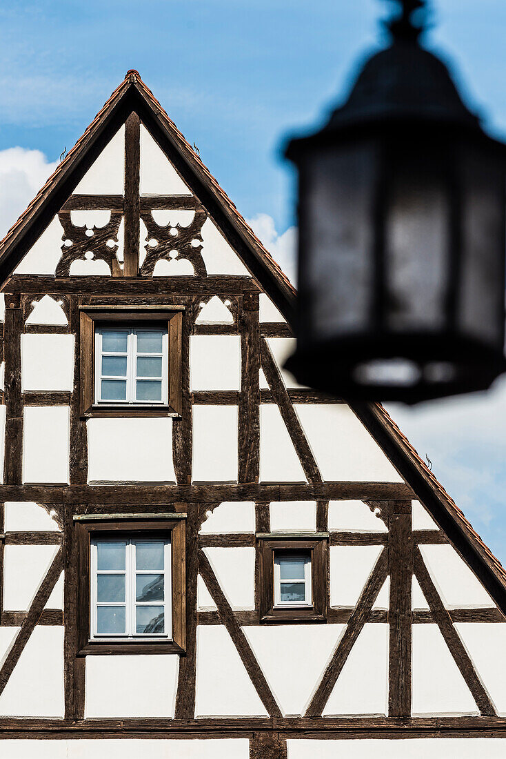 Ein Fachwerkhaus mit einer alten Straßenlampe in der historischen Altstadt, Bamberg, Bayern, Deutschland
