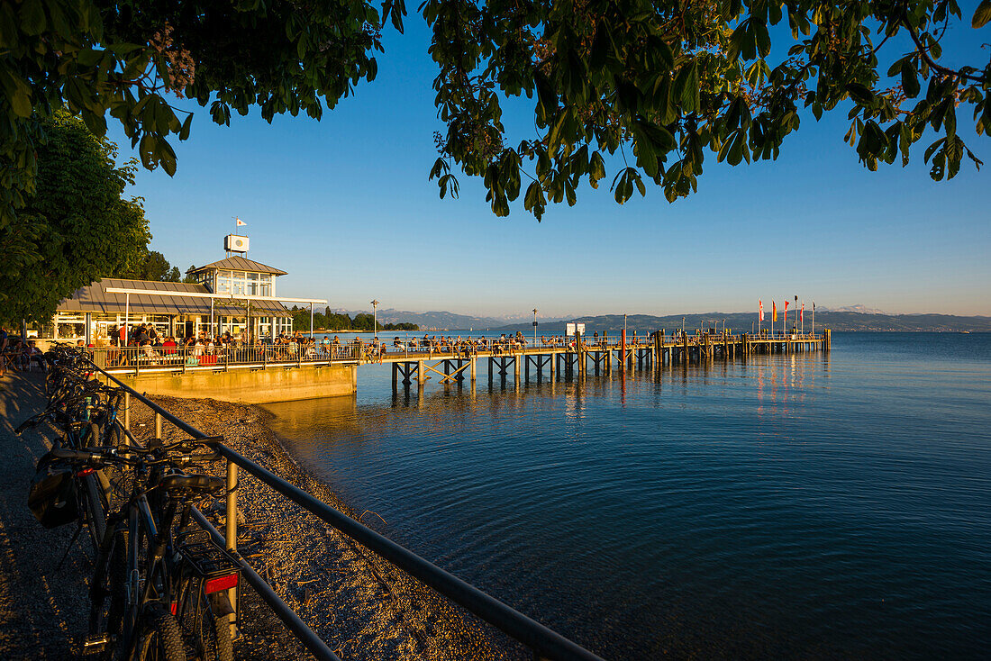 Menschen auf Steg bei Sonnenuntergang, Schiffsanlegestelle Kressbronn, Bodensee, Baden-Württemberg, Deutschland