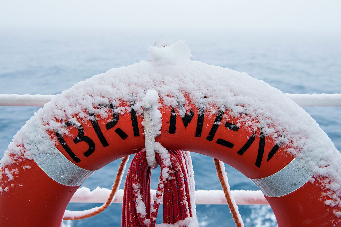 Mit Schnee bedeckter Rettungsring an Bord von Expeditions-Kreuzfahrtschiff MS Bremen (Hapag-Lloyd Cruises) während der Antarktis-Umrundung von Ushuaia in Argentinien nach Bluff in Neuseeland, Rossmeer, Antarktis