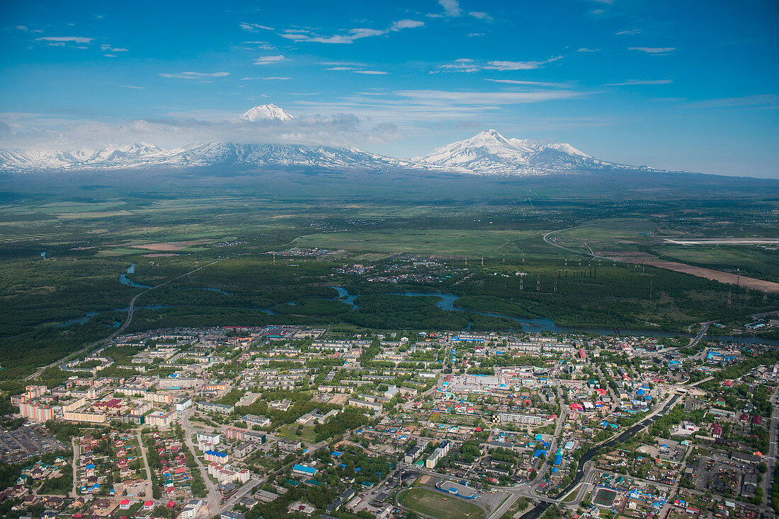 Luftaufnahme von Vororten außerhalb Petropavlovsk-Kamchatsky mit vulkanischen Bergen im Hintergrund vom Hubschrauber aus gesehen, Petropavlovsk-Kamchatsky, Kamtschatka, Russland, Asien