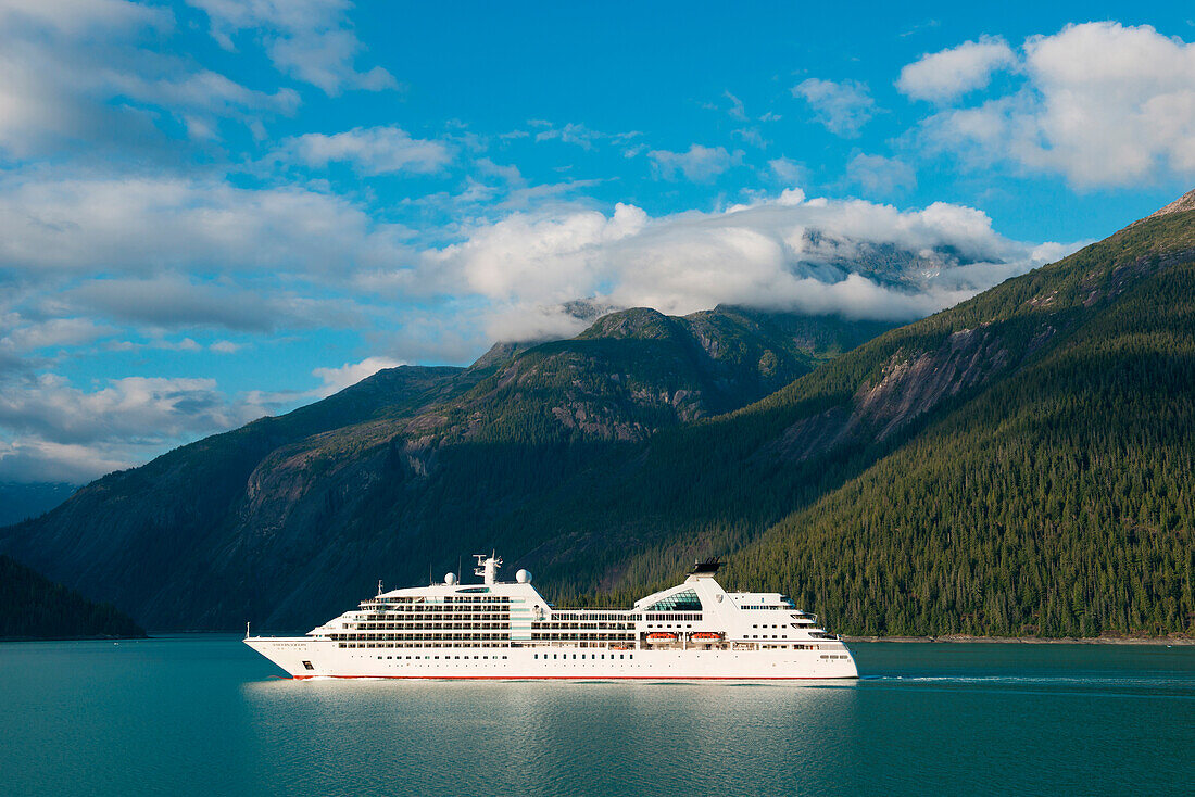 Cruise ship Seabourn Sojourn (Seabourn Cruise Line) passes by forested snow-dusted mountains, Prince Frederick Sound, Alaska, USA, North America