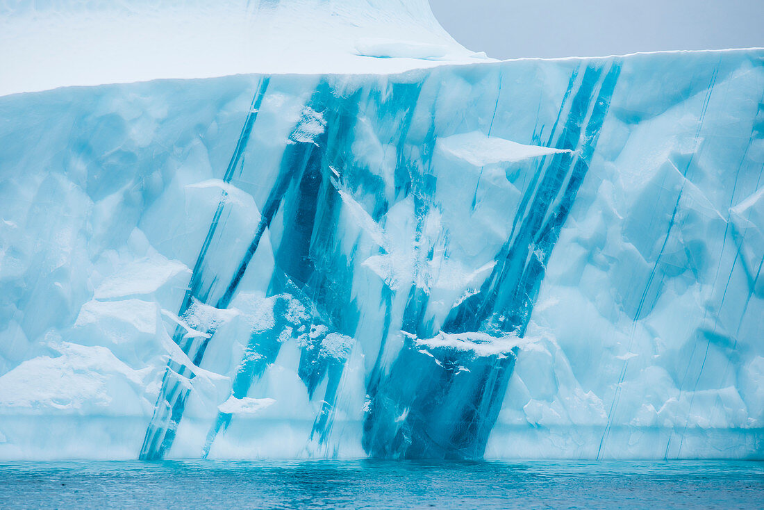 Schnee und Eis in verschiedenen Farben erzeugen kunstvolle Muster in einem Eisberg, Ingmikertikajik, Grönland