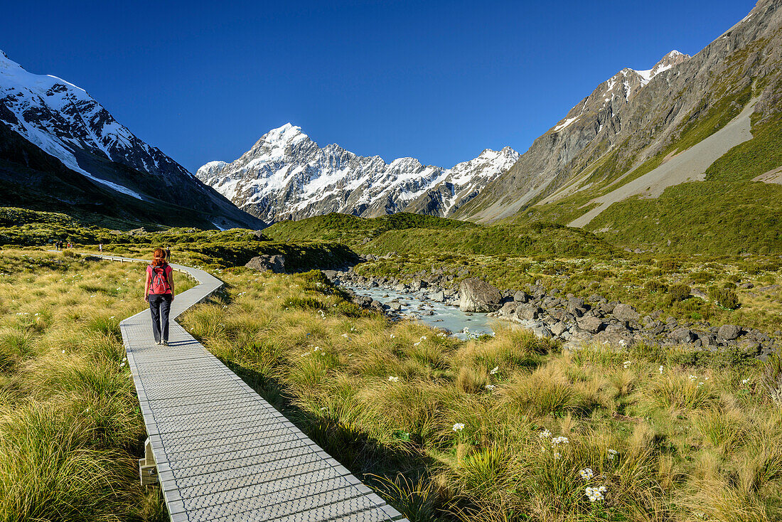 Frau wandert durch Hooker Valley, Mount Cook im Hintergrund, Hooker Valley, Mount Cook Nationalpark, UNESCO Welterbe Te Wahipounamu, Canterbury, Südinsel, Neuseeland