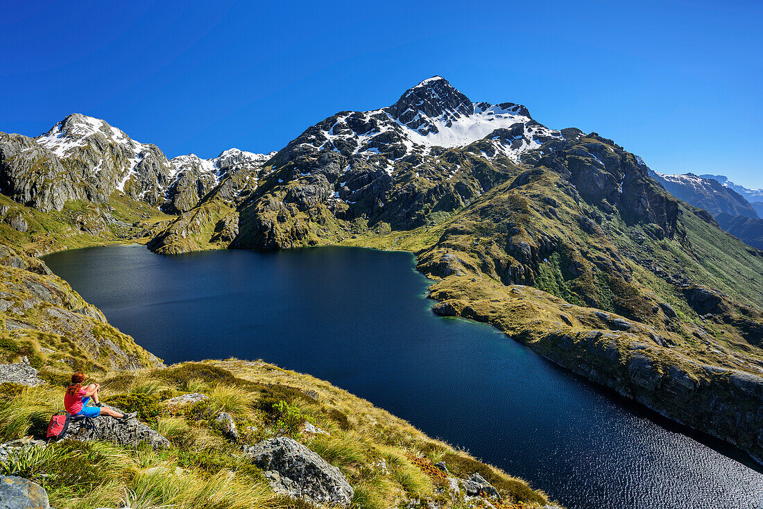 Frau beim Wandern blickt auf Harris Lake, Routeburn Track, Great Walks, Fiordlands Nationalpark, UNESCO Welterbe Te Wahipounamu, Queenstown-Lake District, Otago, Südinsel, Neuseeland