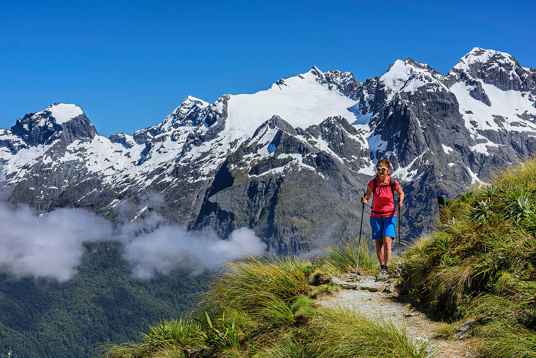 Frau wandert auf Routeburn Track mit neuseeländischen Südalpen im Hintergrund, Routeburn Track, Great Walks, Fiordlands Nationalpark, UNESCO Welterbe Te Wahipounamu, Queenstown-Lake District, Otago, Südinsel, Neuseeland