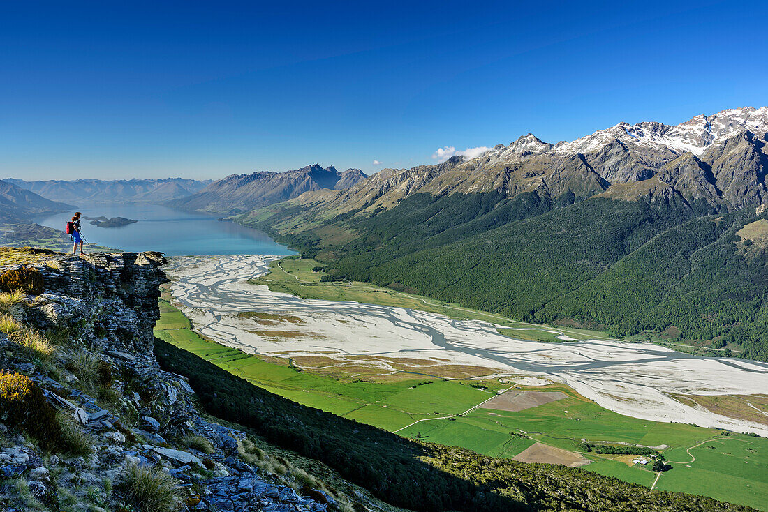 Frau beim Wandern blickt auf Dart River-Tal und Lake Wakatipu, vom Mount Alfred, Fiordlands Nationalpark, UNESCO Welterbe Te Wahipounamu, Queenstown-Lake District, Otago, Südinsel, Neuseeland