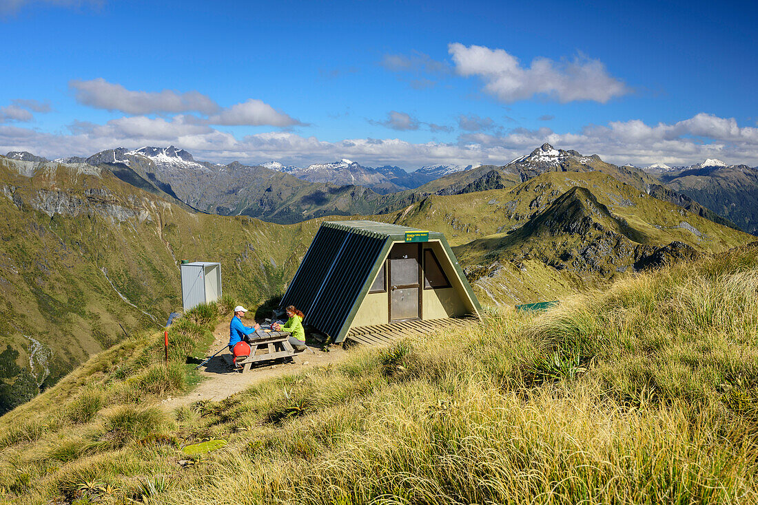 Mann und Frau sitzen an Schutzhütte am Kepler Track, Kepler Track, Great Walks, Fiordlands Nationalpark, UNESCO Welterbe Te Wahipounamu, Southland, Südinsel, Neuseeland