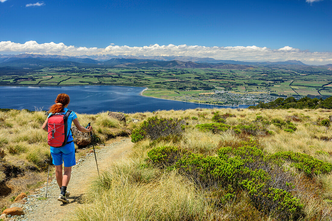 Woman hiking on Kepler Track with view towards Lake Te Anau, Kepler Track, Great Walks, Fiordland National Park, UNESCO Welterbe Te Wahipounamu, Southland, South island, New Zealand