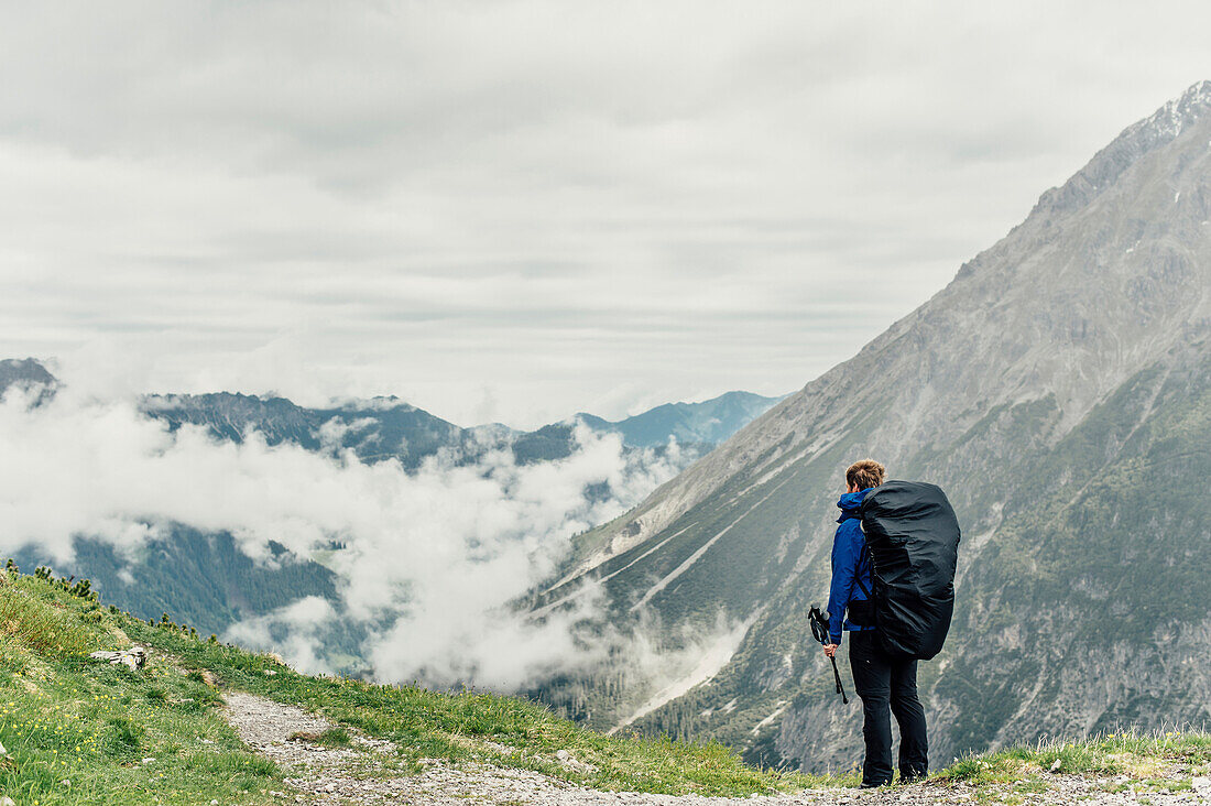 Hiker with backpack in Brandnertal, Vorarlberg, austria, europe.