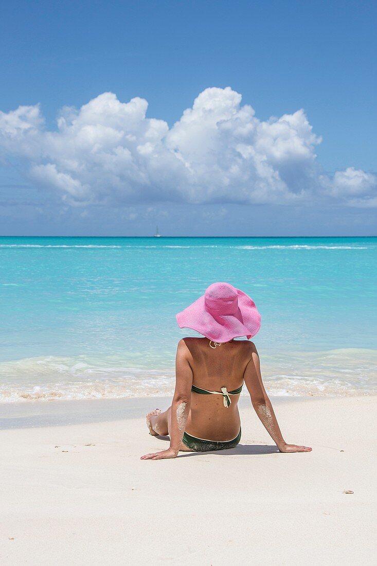 Tourist admires the turquoise Caribbean Sea Jolly Beach Antigua and Barbuda Leeward Island West Indies.