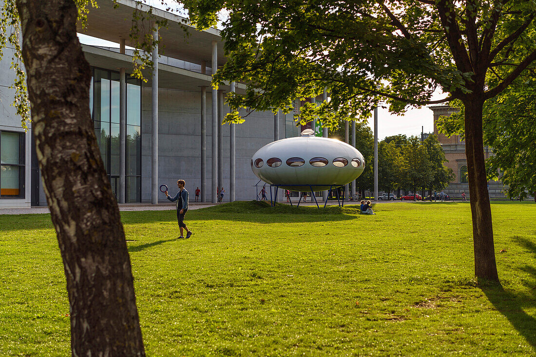 Ein Mann spielt Frisbee vor dem Futuro-Haus von Matti Suuronen bei der Pinakothek der Moderne, München, Oberbayern, Deutschland