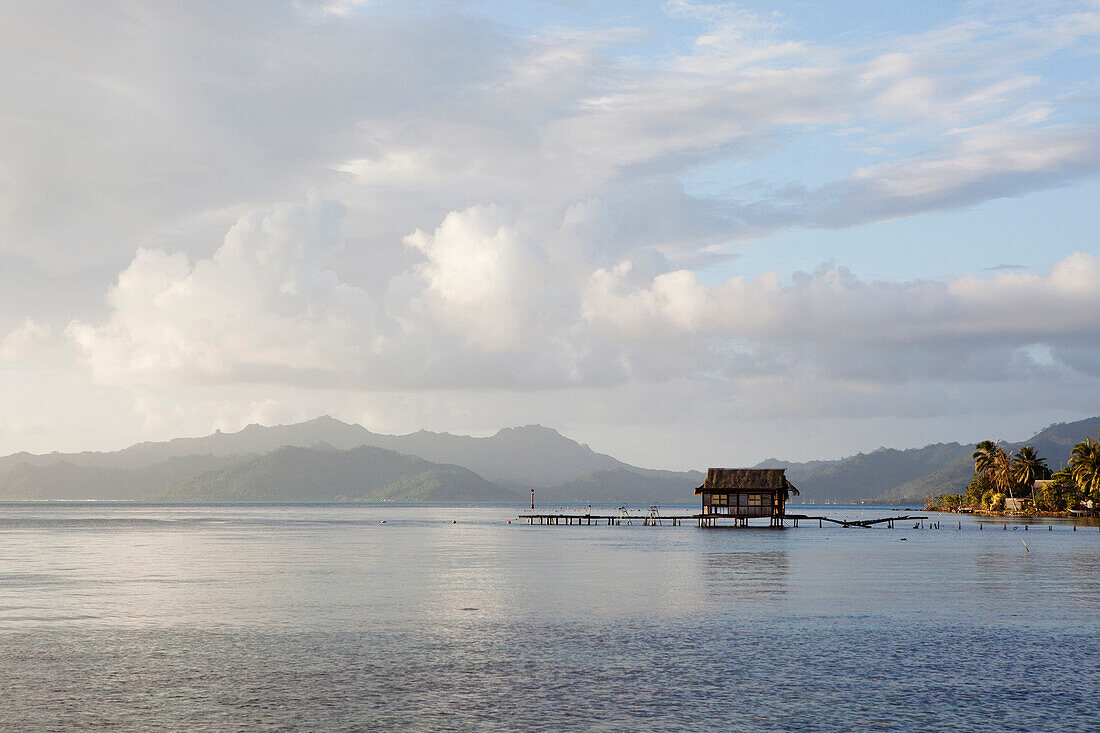 FRENCH POLYNESIA, Raiatea Island. A view of the coastline of Raiatea Island. An abandoned pearl farm hut can be seen in the distance.