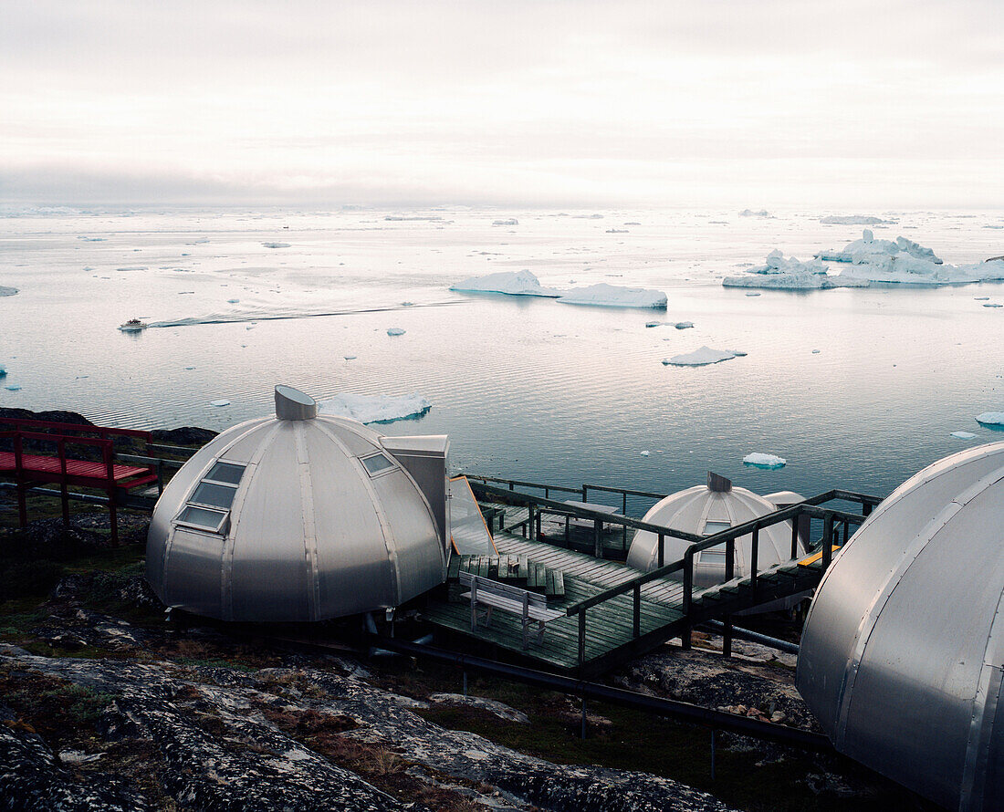 GREENLAND, Ilulissat, Disco Bay, elevated view of Hotel Arctic with icebergs and the sea in the background