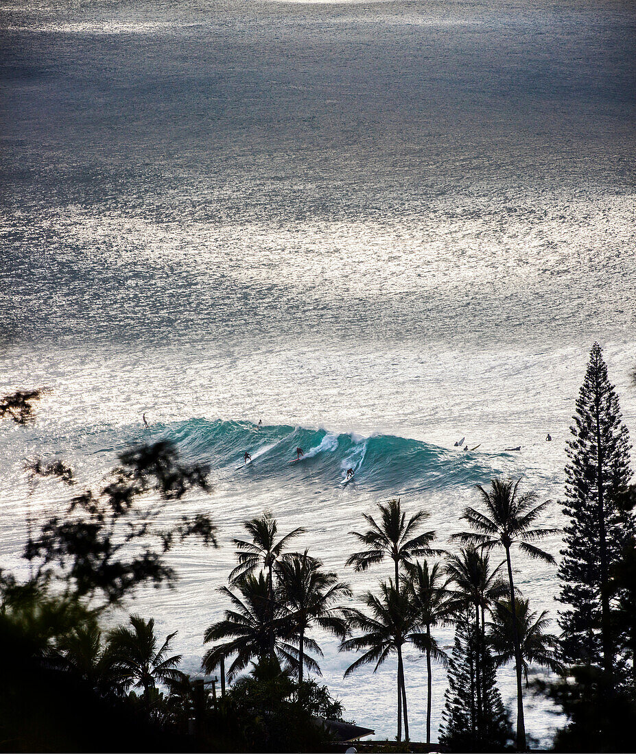 HAWAII, Oahu, North Shore, surfers in the water at Waimea Bay