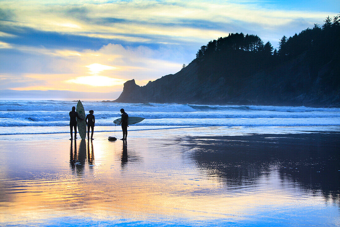 USA, Oregon, Oswald West State Park, surfers walk along the beach and out into the water at Oswald State Park, just south of Cannon Beach