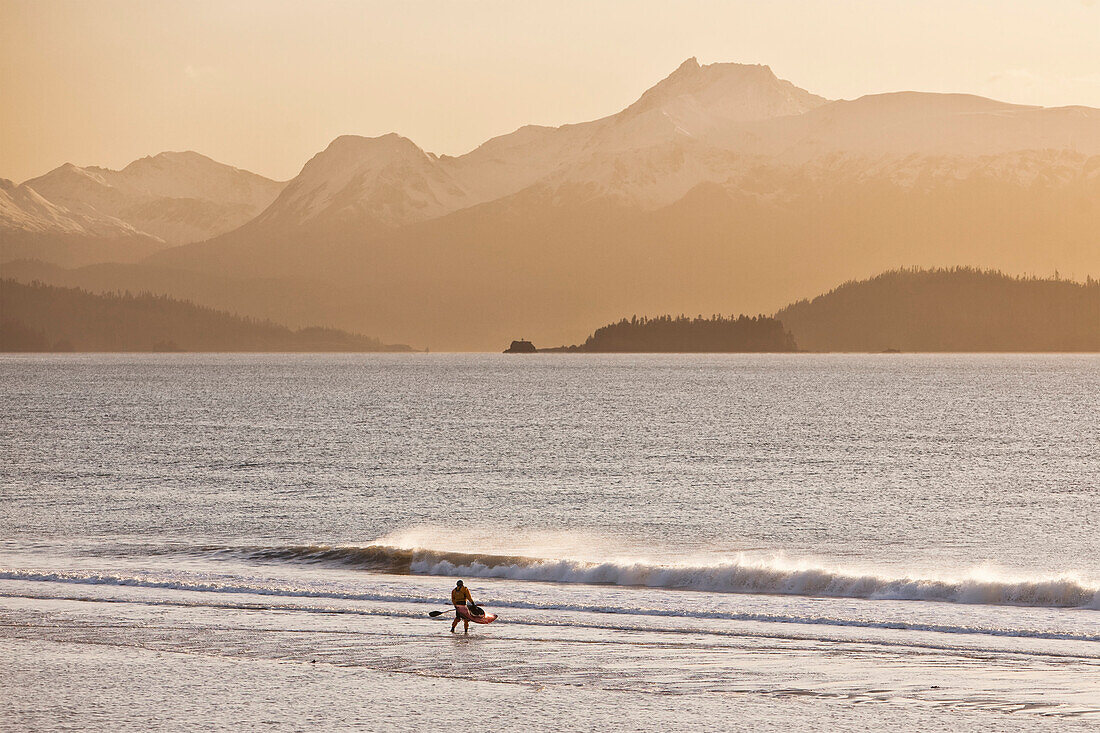 Kayaker Standing On Beach, Kachemak Bay With Kenai Mountains In The Background, Homer Spit, Southcentral Alaska, USA