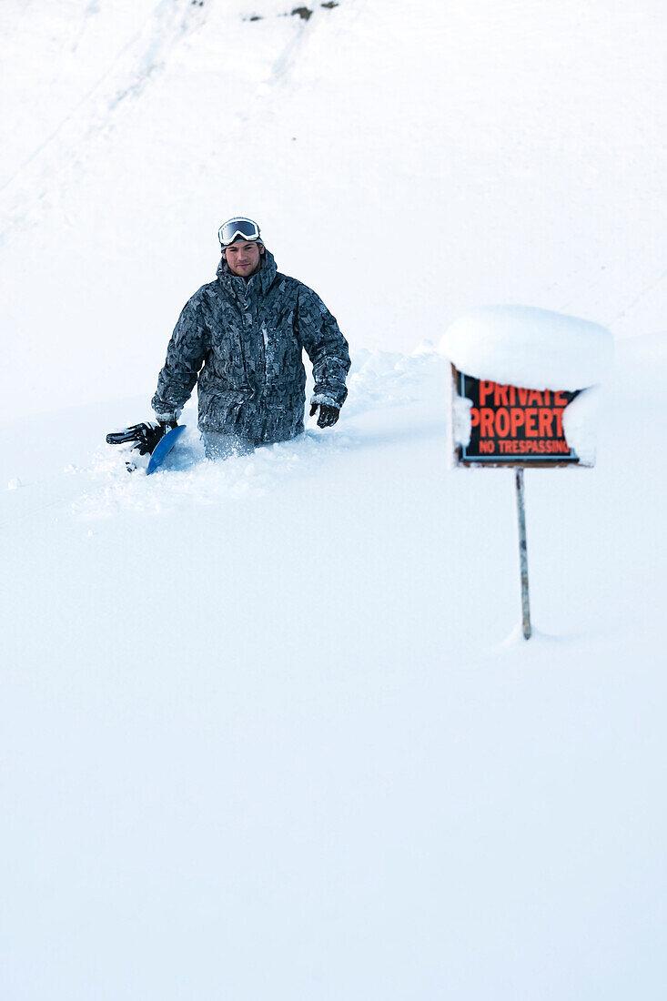 Snowboarder in deep snow on private property, Homer, Southcentral Alaska, USA