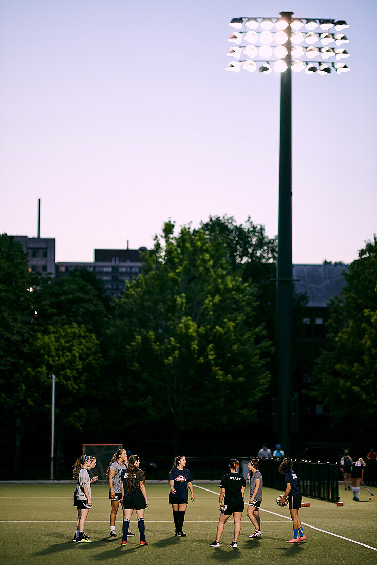 Sports Team Practice On A Field On The University Of Toronto Campus At Dusk; Toronto, Ontario, Canada