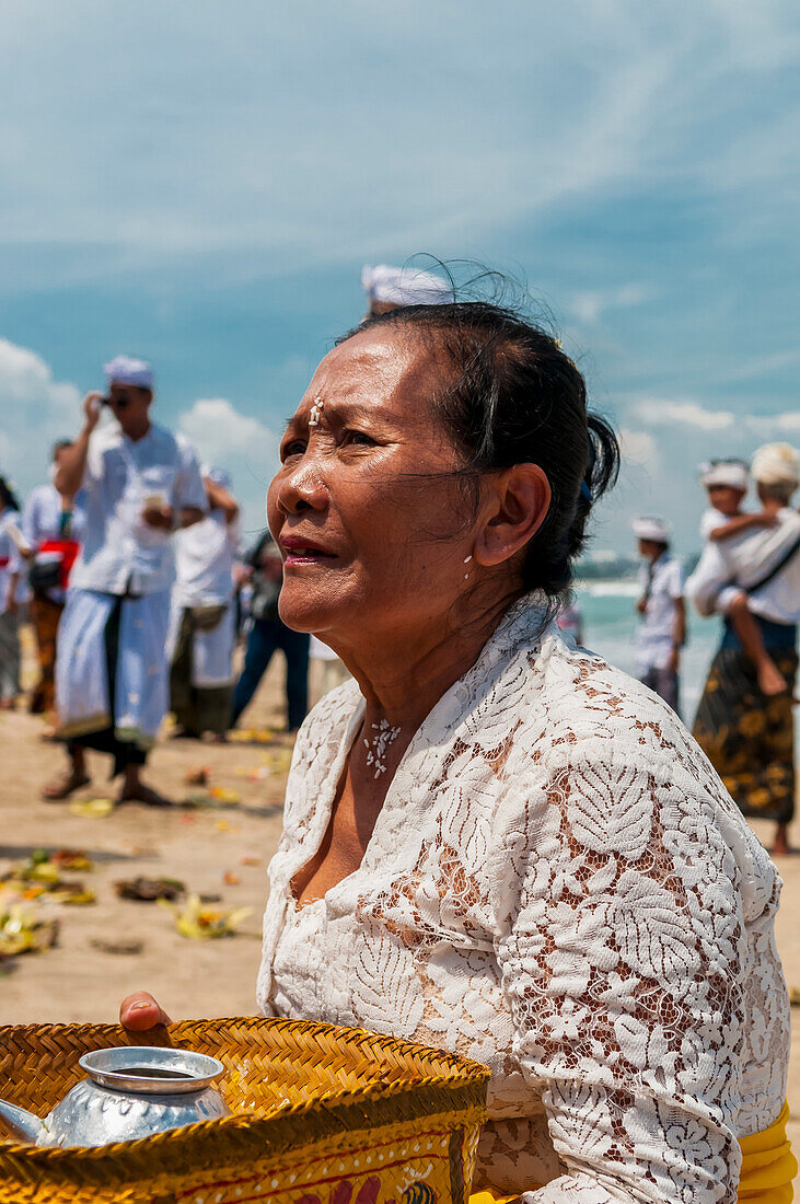 A Senior Women At A Religious Ceremony On The Beach; Bali, Indonesia