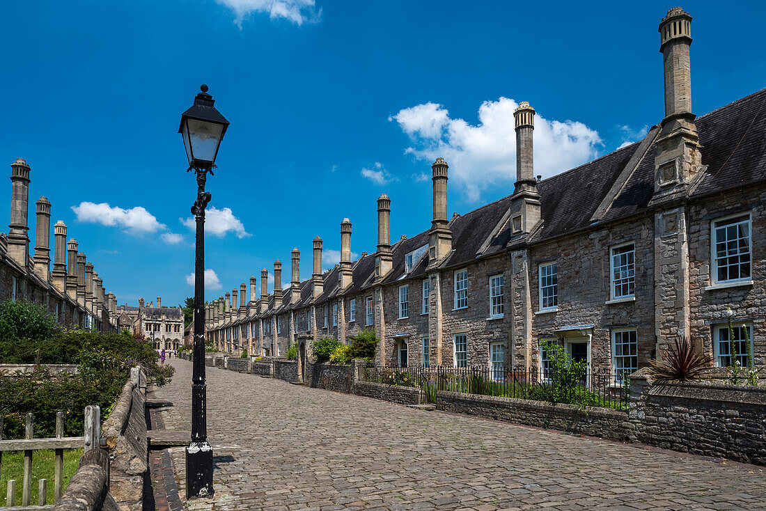 Historic houses on Vicars' Close with a street lamp and cobblestone street. Built between 1348 and 1430, Vicars’ Close is claimed to be the oldest purely residential street with its original buildings all surviving intact in Europe; Wells, Somerset, Engla