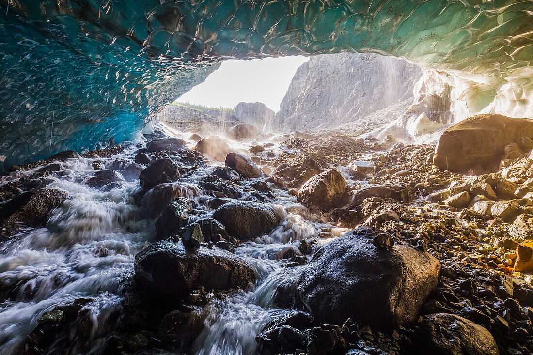 Water cascades over rocks inside a cave beneath the ice of Root Glacier in Wrangell-St. Elias National Park; Alaska, United States of America